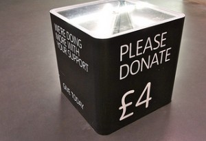 Black donation box, with bold white message: please donate 